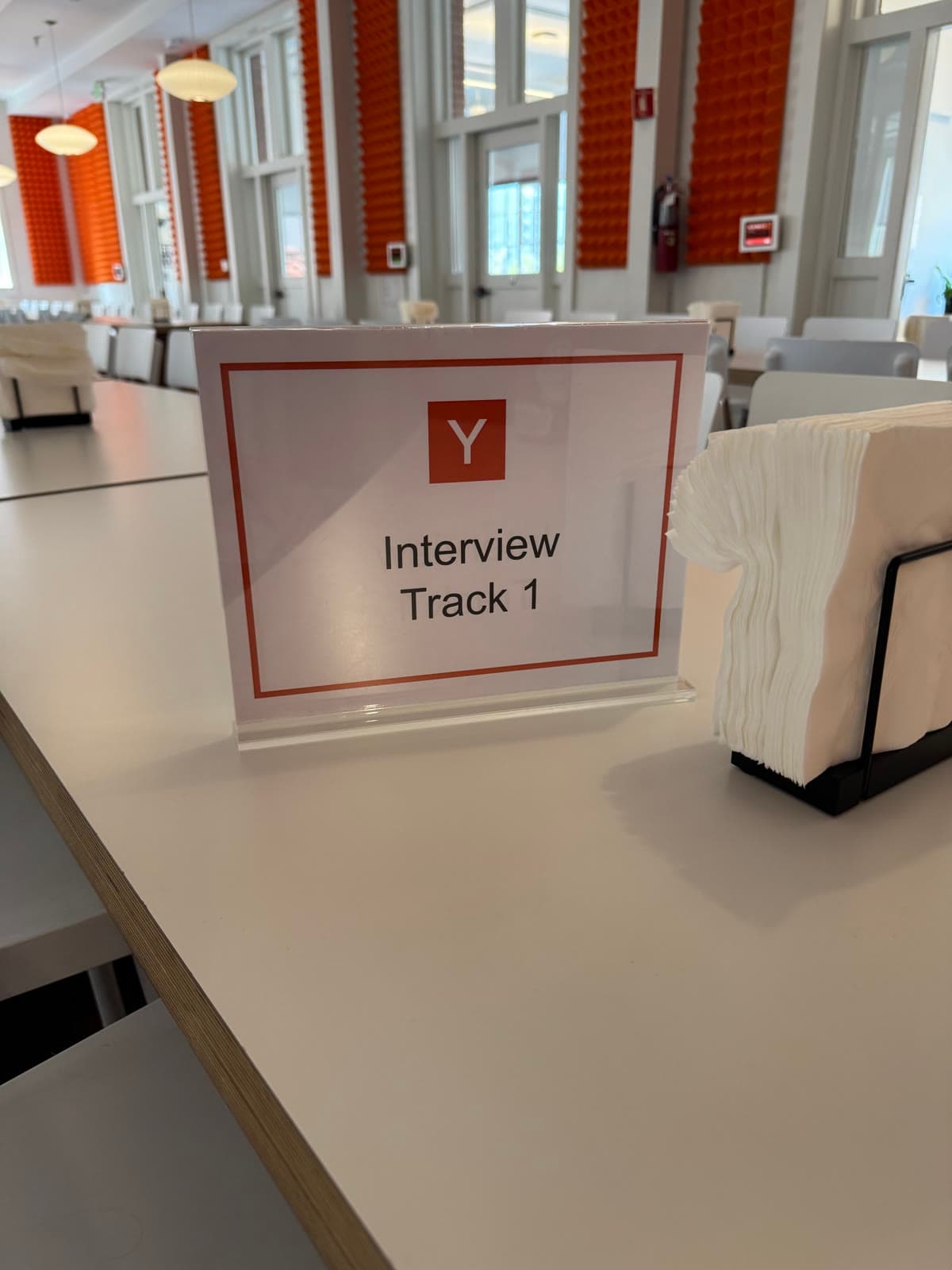 An acrylic table sign reading Y / Interview Track 1, in the YC cafeteria